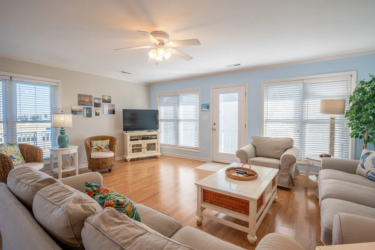This image features a comfortable seating area with a television, decorative lamps, and a view to the outdoors through a door. The space suggests cozy family gatherings and an easy transition between indoor and outdoor enjoyment, hinting at the flexibility and comfort available to guests year-round.