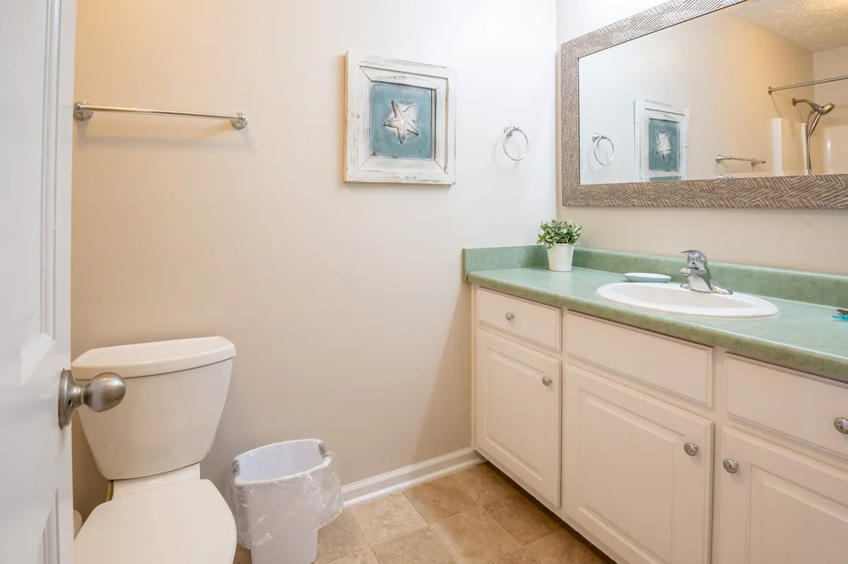 A calm and inviting bathroom with a green countertop, star-themed wall art, and a sink with faucet. The space feels refreshing and tranquil, ideal for personal grooming or winding down at the end of the day.